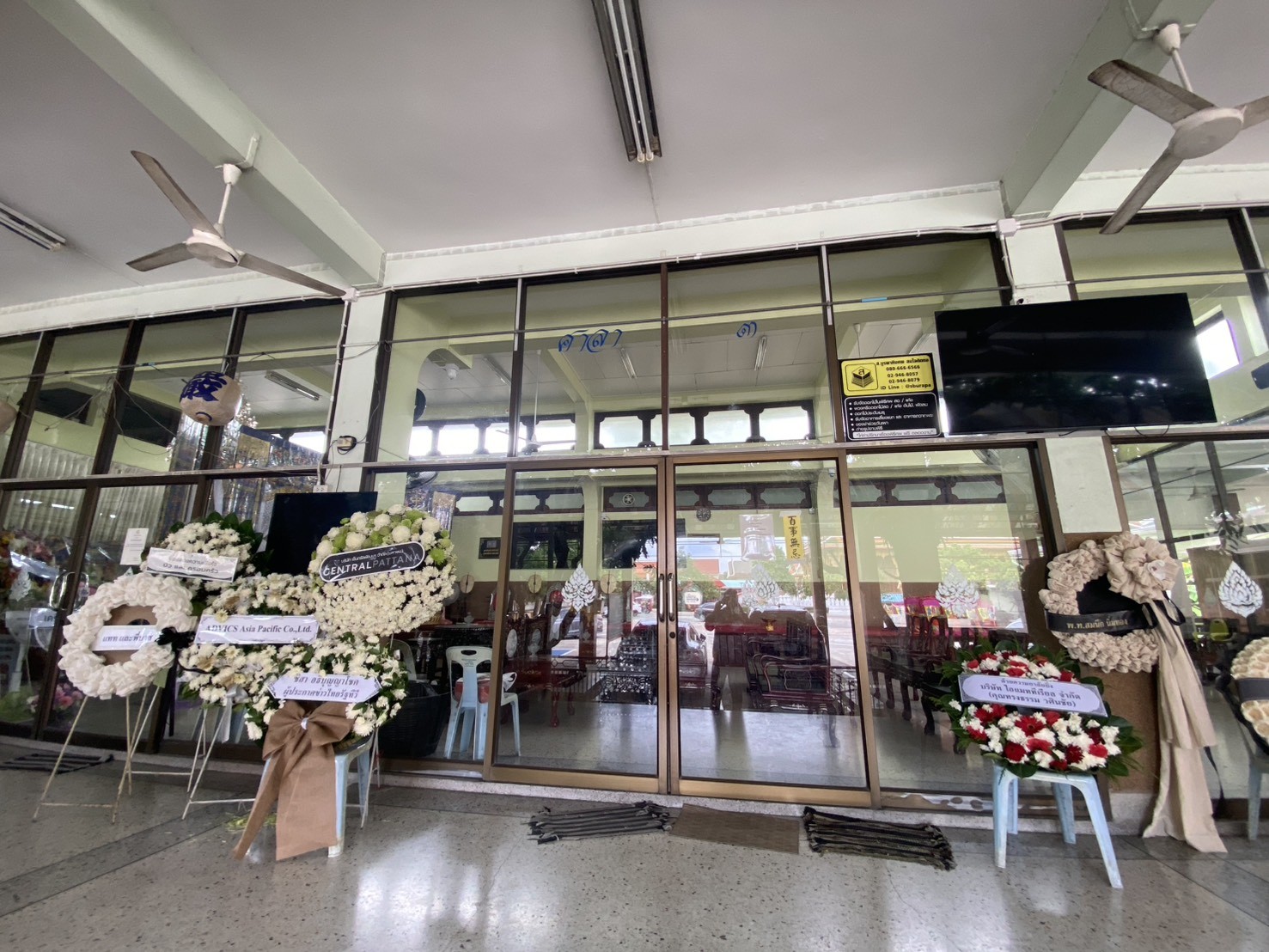 ศาลาสวดอภิธรรมวัดนวลจันทร์ที่มีพวงหรีดจัดวางเรียงรายรอส่งถึงเจ้าภาพ